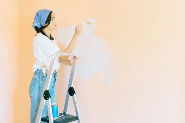 Interior painting in Lubbock: painter on a stepladder rolling a wall